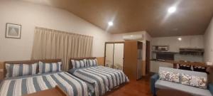 a bedroom with two beds and a kitchen at Wind Valley Homestay in Lugu Lake