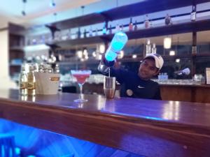 a man is making a drink at a bar at Marina Del Ray in Pelangan