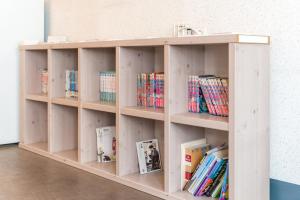 a wooden book shelf filled with books in a room at Dongseongro ZERO guesthouse in Daegu