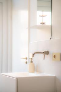 uma casa de banho com um lavatório e um espelho em Art Apartment newly build 7min from Rotterdam CS app1 em Schiedam