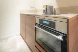 a kitchen with a stove and a counter top at Art Apartment newly build 7min from Rotterdam CS app1 in Schiedam