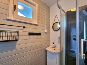 a bathroom with a sink and a shower at Domki z jacuzzi nad zatoką in Puck +26 photos