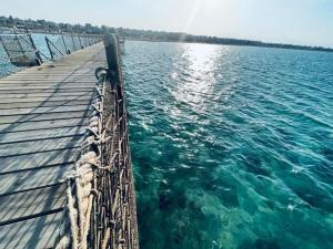 a wooden pier in the water next to the ocean at Blue Bay Asia Sokhna Aqua park بلو باي اسيا العين السخنه - عائلات فقط in Ain Sokhna