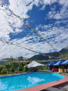 a resort swimming pool with mountains in the background at Mussoorie Camp Resort in Mussoorie