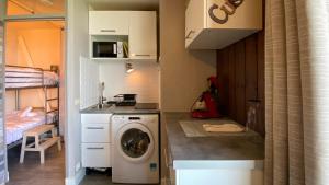 uma pequena cozinha com uma máquina de lavar roupa num quarto em Le Cosy Vertigineux em Uvernet