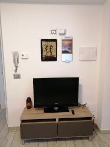 TV de pantalla plana en la parte superior de un centro de entretenimiento en Apartment, en Materdomini