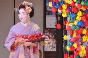 a woman dressed in a kimono standing in a store at 京町家の宿 三石 in Kyoto