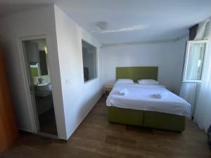 a small bedroom with a bed and a sink at Apartments Grand in Sveti Stefan