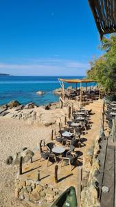 een rij tafels en stoelen op een strand bij Villas Abbartello in Olmeto