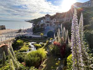 a view of a garden with flowers and the ocean at No 5 Old Church in Ventnor