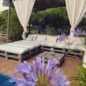 a patio with two beds and purple flowers at El Atico de Villalmar in Tui