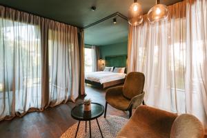 een slaapkamer met een bed, een bank en een tafel bij Floris Green Suites by Parc Hotel Florian in Siusi