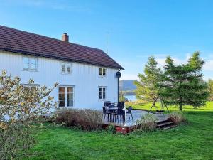 una casa blanca con una mesa y sillas en un patio en Holiday home Vallersund, 