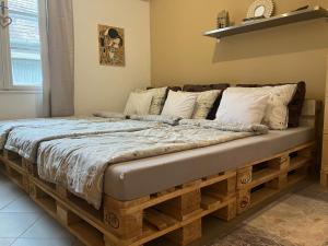 un letto fatto di pallet in una camera da letto di Karneol Apartman a Balatonfenyves