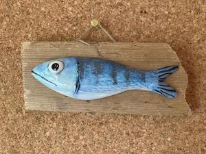 un pesce su un pezzo di legno con un filo di Karneol Apartman a Balatonfenyves