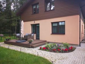 a house with a patio and flowers in the yard at Kristinos apartment in Druskininkai