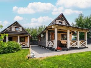 una pequeña casa con un porche en un patio en DOMKI KARKONOSZE SEN DOBRY en Podgórzyn