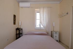 Schlafzimmer mit einem Bett und einem Fenster in der Unterkunft Villa Luce in Chalki