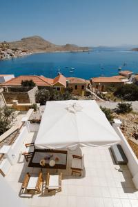 a large white umbrella on a patio with a view of the ocean at Villa Luce in Halki
