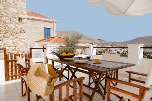 an outdoor patio with a wooden table and chairs at Villa Luce in Halki