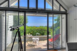 a camera on a tripod in a room with a sliding glass door at Little West Hill Studio in Lyme Regis
