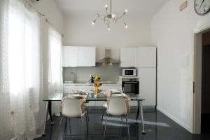 a kitchen with a glass table and white cabinets at Artemisia in Viareggio