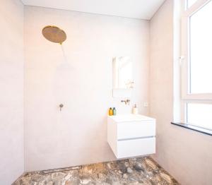 a white bathroom with a sink and a mirror at The Den Newly Build Apartment 7-Minutes From Rotterdam City Central Station app2 in Schiedam