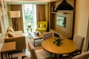 ein Wohnzimmer mit einem Tisch, Stühlen und einem TV in der Unterkunft The Padgett Suites in Cebu City