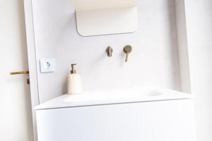 een witte koelkast met een wastafel in een kamer bij Luxurious Penthouse Newly Build just 7-Minutes from Rotterdam CS City app3 in Schiedam