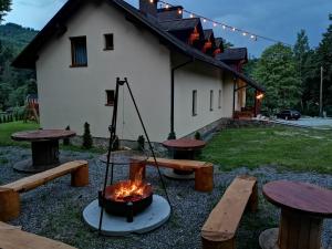a backyard with a fire pit and picnic tables at Apartamenty Sadowy in Wisła