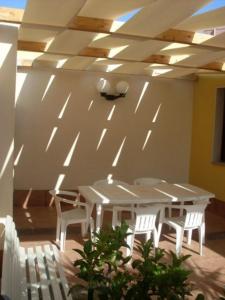 アヴォラにあるVespri Sicilianiの天井の客室で、テーブルと椅子が備わります。
