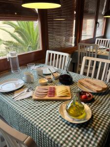 una mesa con un mantel verde y blanco con comida. en Ca La Gràcia en Cabrianas