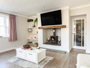a living room with a fireplace and a tv at Carreg Y Garth in Caernarfon