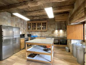 a kitchen with a stainless steel refrigerator and wooden cabinets at Palacio de Aralar Grande in Oskotz