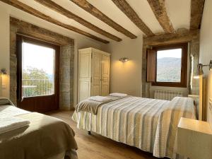 a bedroom with two beds and two windows at Palacio de Aralar Grande in Oskotz