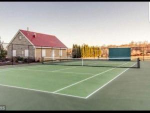 um campo de ténis com uma rede de ténis e um edifício em Hidden Gem near Downtown Frederick and shopping em Frederick