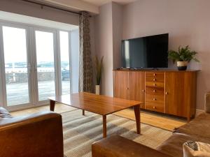 a living room with a tv and a coffee table at Contemporary living with amazing views. Pembrokeshire in Pembrokeshire