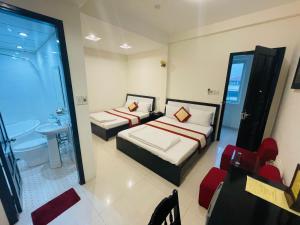 a hotel room with two beds and a bathroom at Canary Hotel Hue in Hue