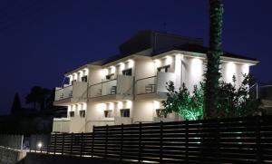 a white building with lights on it at night at Armonia Rooms in Laganas