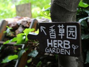 a sign on a tree that reads her garden at The Bivou Lijiang in Lijiang