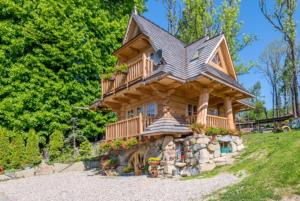 una casa in legno con balcone su una collina. di Bajkowy domek a Kościelisko
