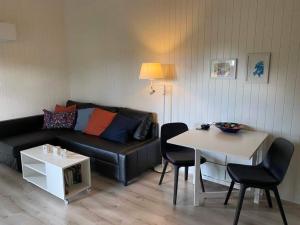 sala de estar con sofá y mesa con sillas en Kattalängan - Lilla huset, en Brösarp