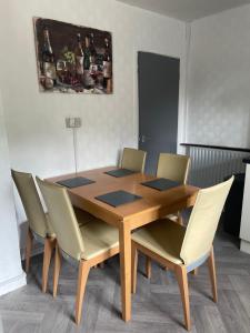 una mesa de comedor con sillas y una pintura en la pared en The Cresent WV1 - 3 Bedroom House, Table Soccer, Parking, Garden, en Monmore Green