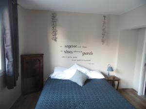 Un dormitorio con una cama azul con escritura en la pared en Hôtel & Restaurant Lepassplat, en Montbrison