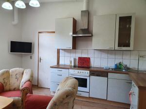 a kitchen with white cabinets and a stove top oven at Ferienwohnung Ost - Alte Schule Sachswitz in Greiz