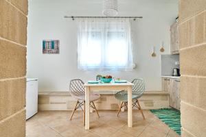 eine Küche mit einem Tisch und Stühlen sowie einem Fenster in der Unterkunft Semeli Apartment in Kissamos