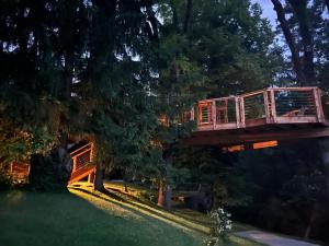 una casa en un árbol con un puente en un patio en Apartments Kokl - Adults only, en Radovljica