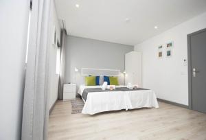 a white bedroom with a bed in a room at In Downtown - Villa Serenity in Albufeira
