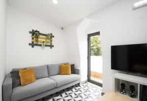 a living room with a couch and a flat screen tv at In Downtown - Villa Serenity in Albufeira