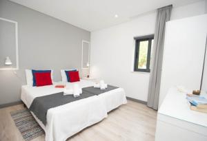 a bedroom with two beds with red and blue pillows at In Downtown - Villa Serenity in Albufeira